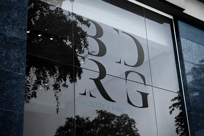 Damien Digital, design UXUI, designer, BDRG Avocats Paris, mockup logo gravé sur vitrine en verre, façade de cabinet avec reflets d'arbres, fond bleu nuit