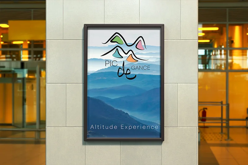Damien Digital, design UXUI, designer, Pic de Gance, station de ski, mockup affiche encadrée en intérieur, logo Altitude Experience fond montagnes bleu brumeux, hall vitré lumineux