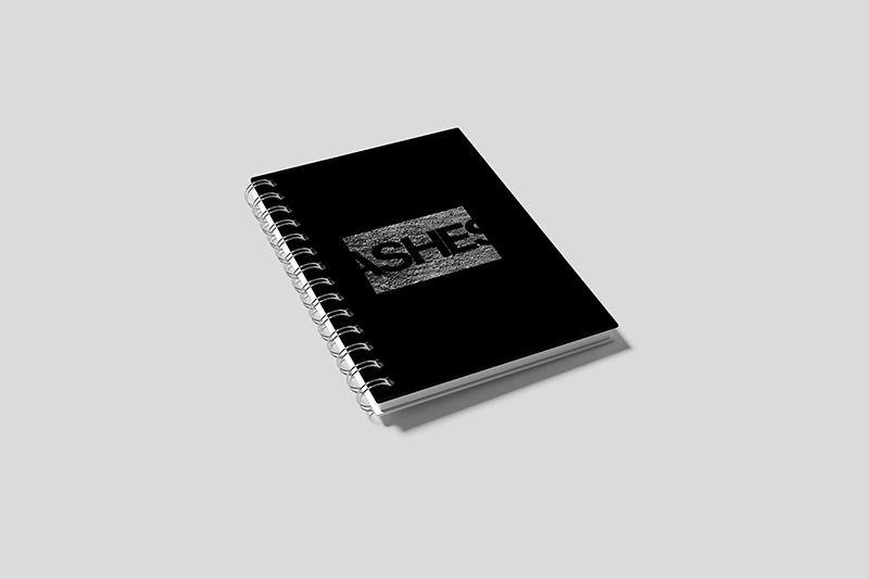 Damien Digital, design UXUI, designer, revue Ashes art contemporain, mockup carnet relié spirale, couverture noire logo texturé effet béton gris, fond gris clair uni